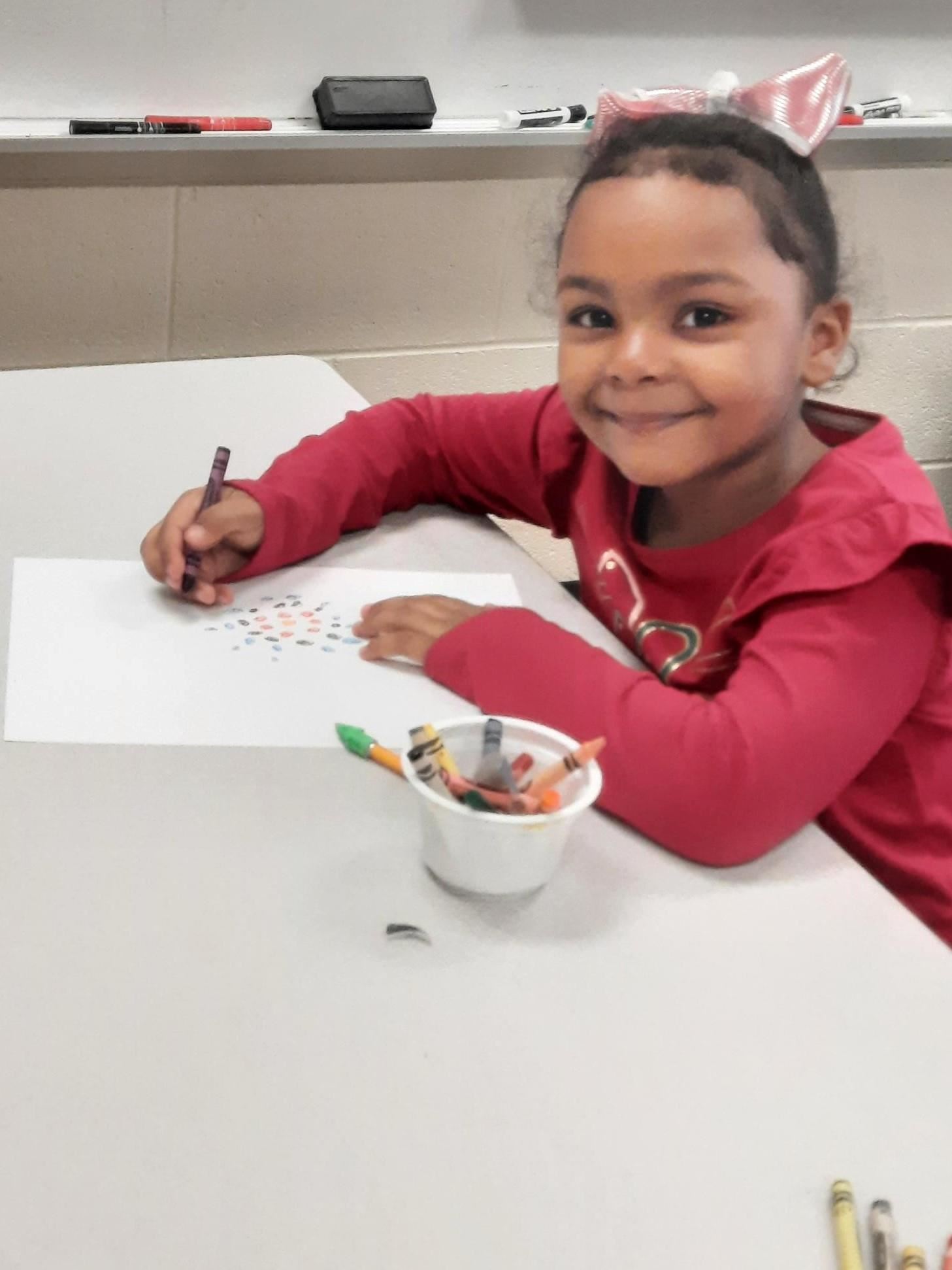 Photo shows a girl in an art class making a project in the style of artist Alma Thomas.